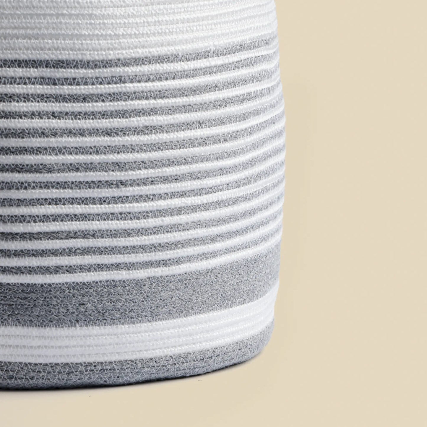 The bottom right detail of the Loom chandelier is handmade from cotton rope. It is white with grey details.