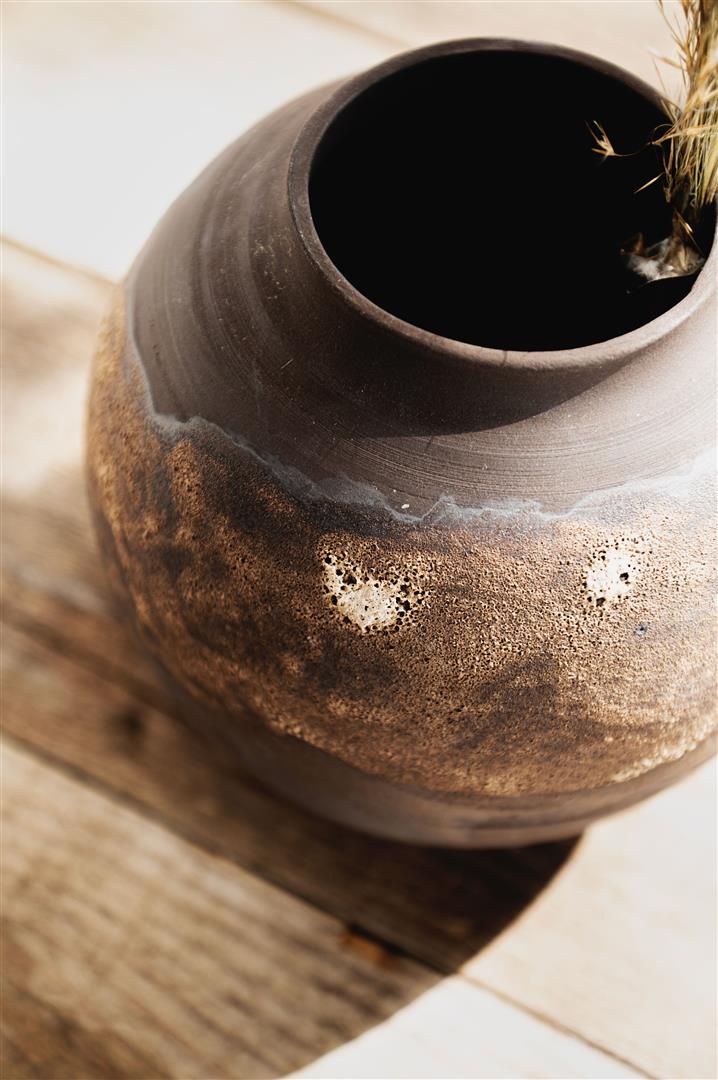 Ceramics vase with golden glaze and dark brown background