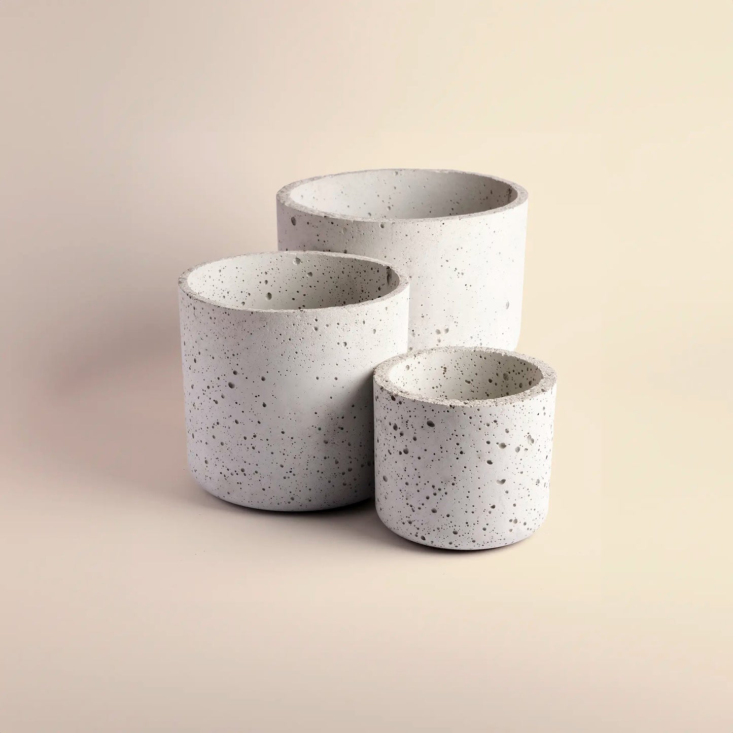 Three plant pots handmade from concrete, large, medium and small. 