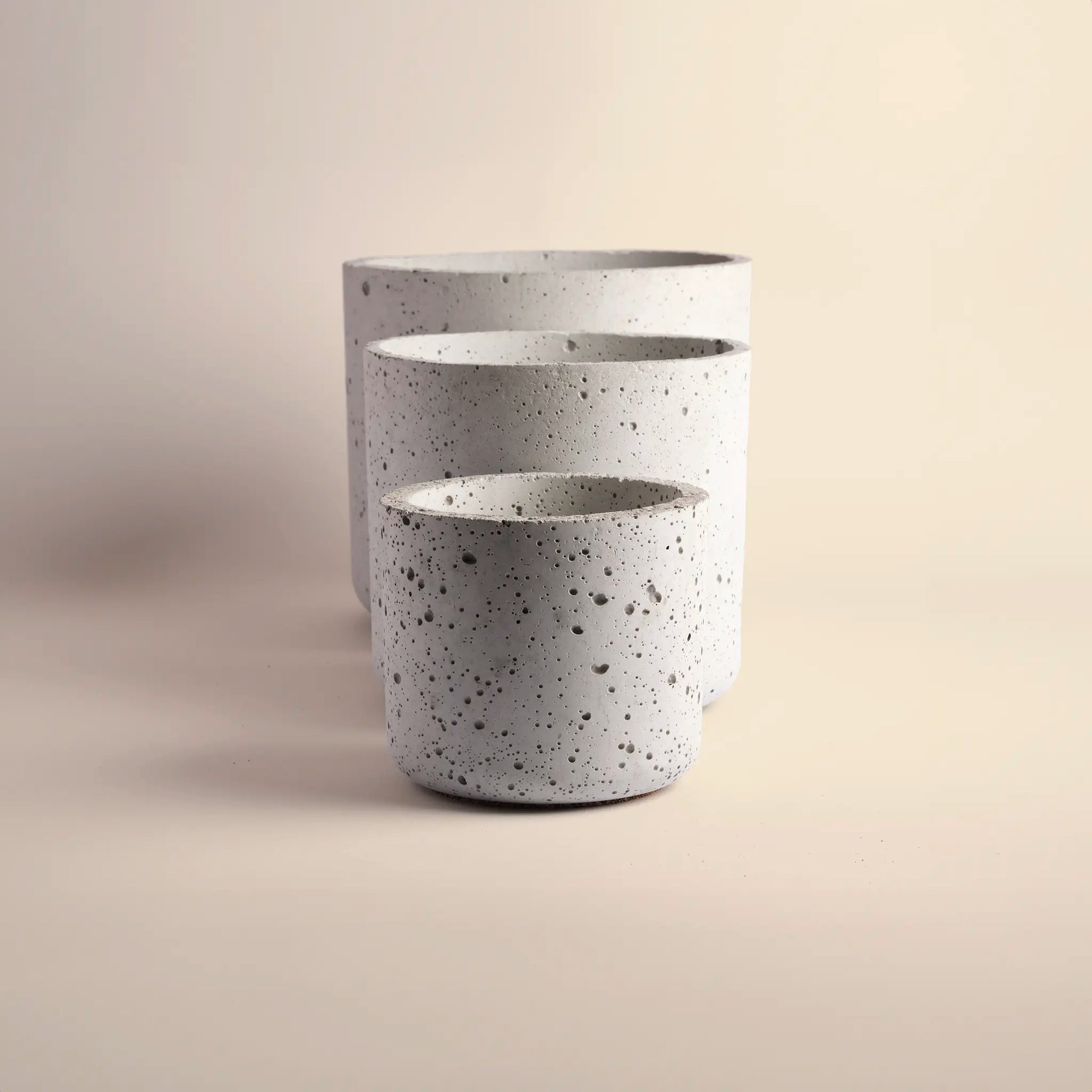 Set of three plant pots handmade from concrete, large, medium and small. 