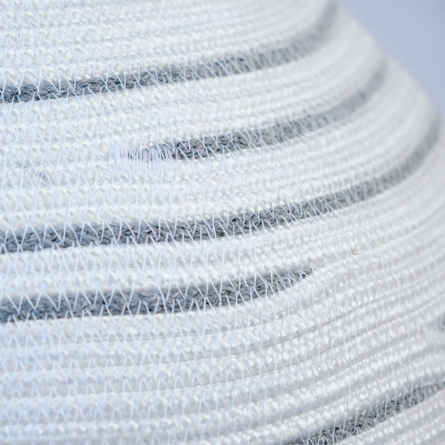 Large Halo chandelier made from cotton rope. It is white with grey details. The image is a detail of a stitch.