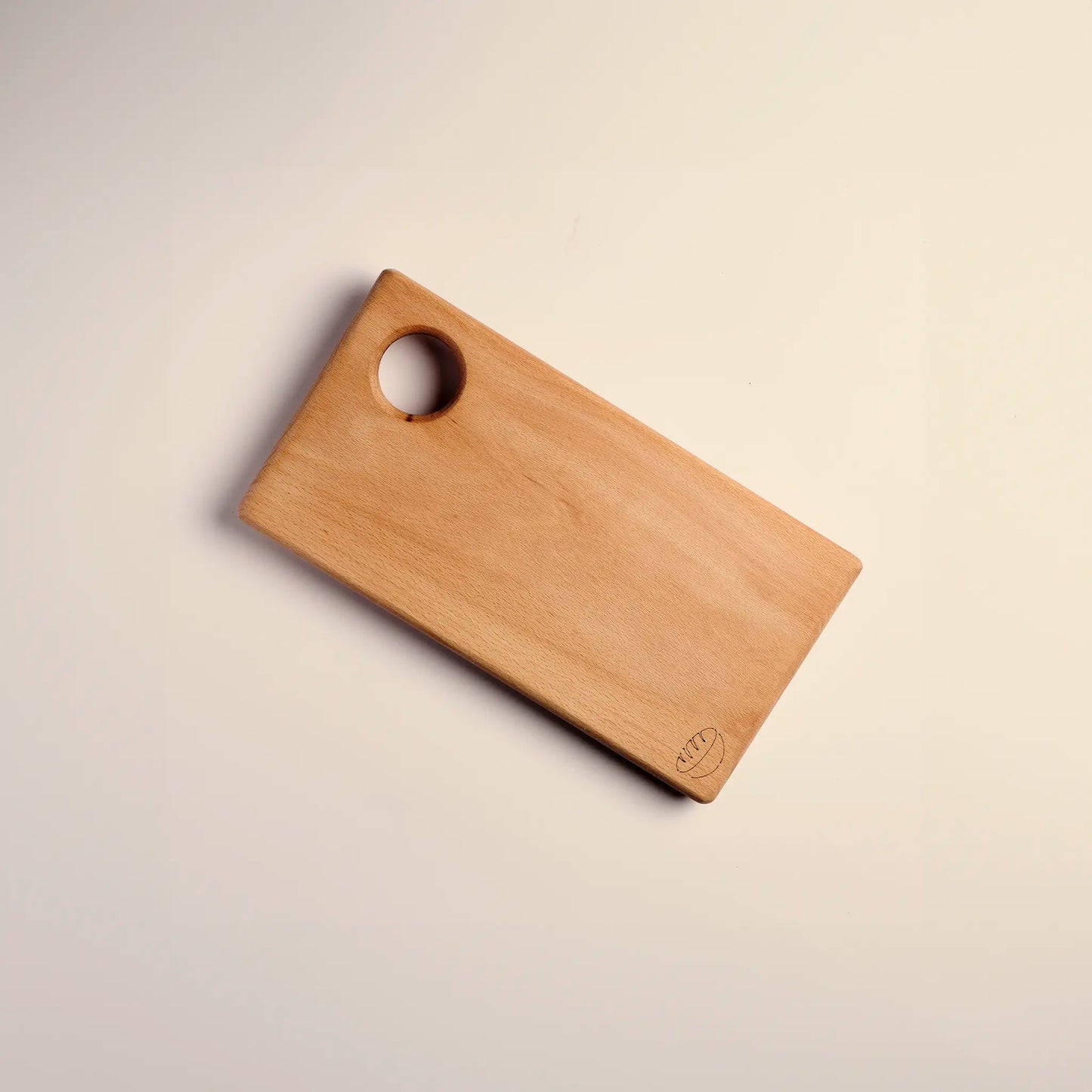 Cutting board handmade from beech wood with carved image of a bread. 