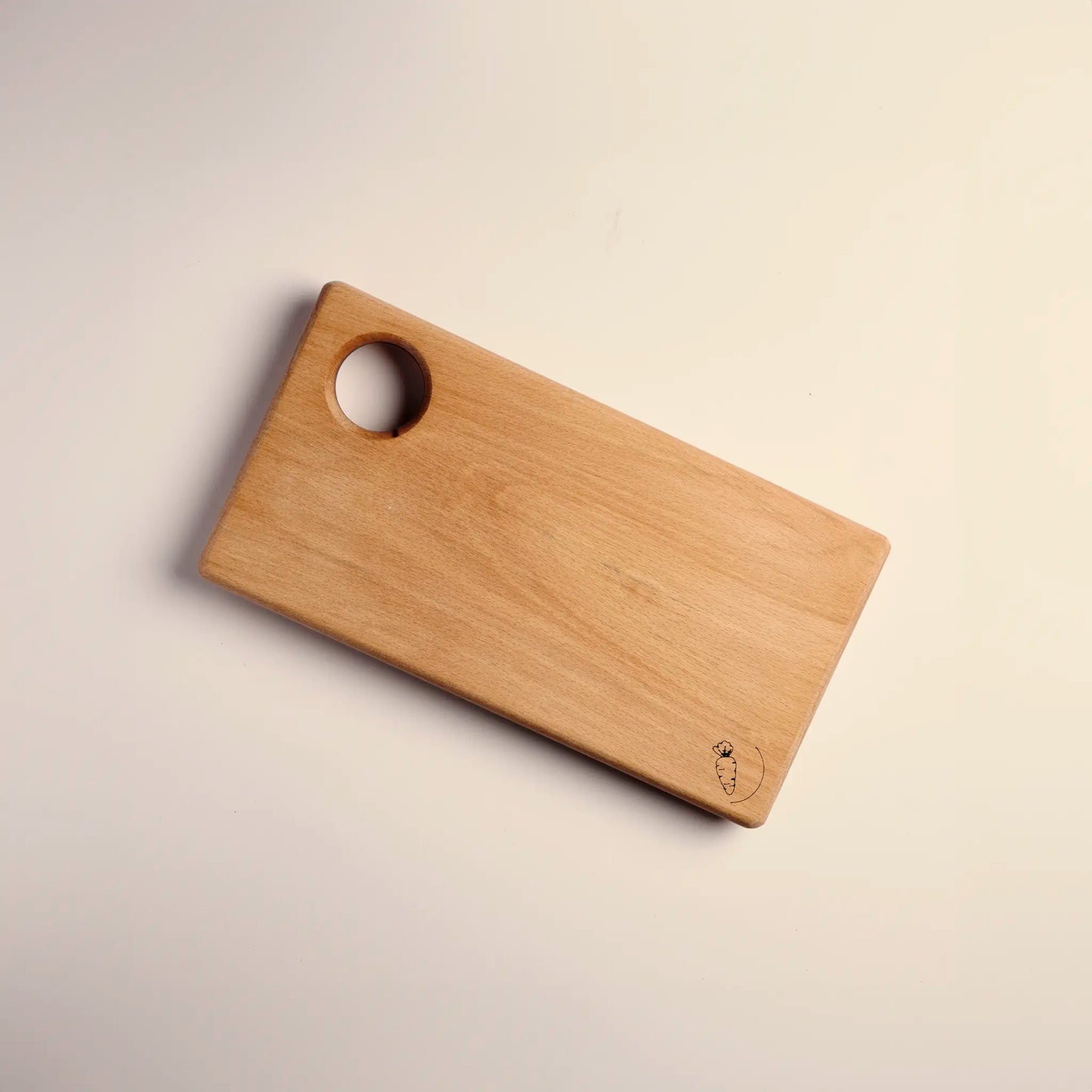 Cutting board handmade from beech wood with carved image of a carrot. 