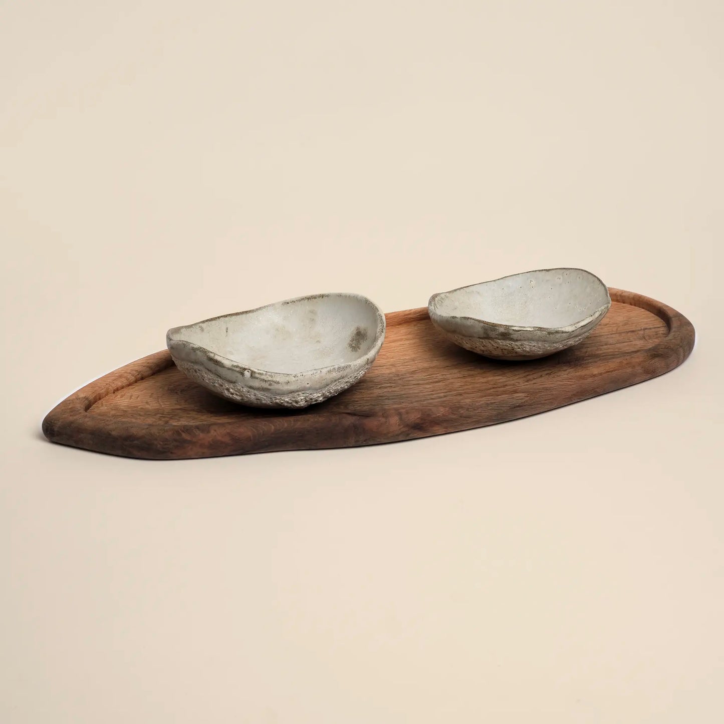 Lava Pulse Ceramics Set is a handmade set of two small ceramics bowls on a wooden board.