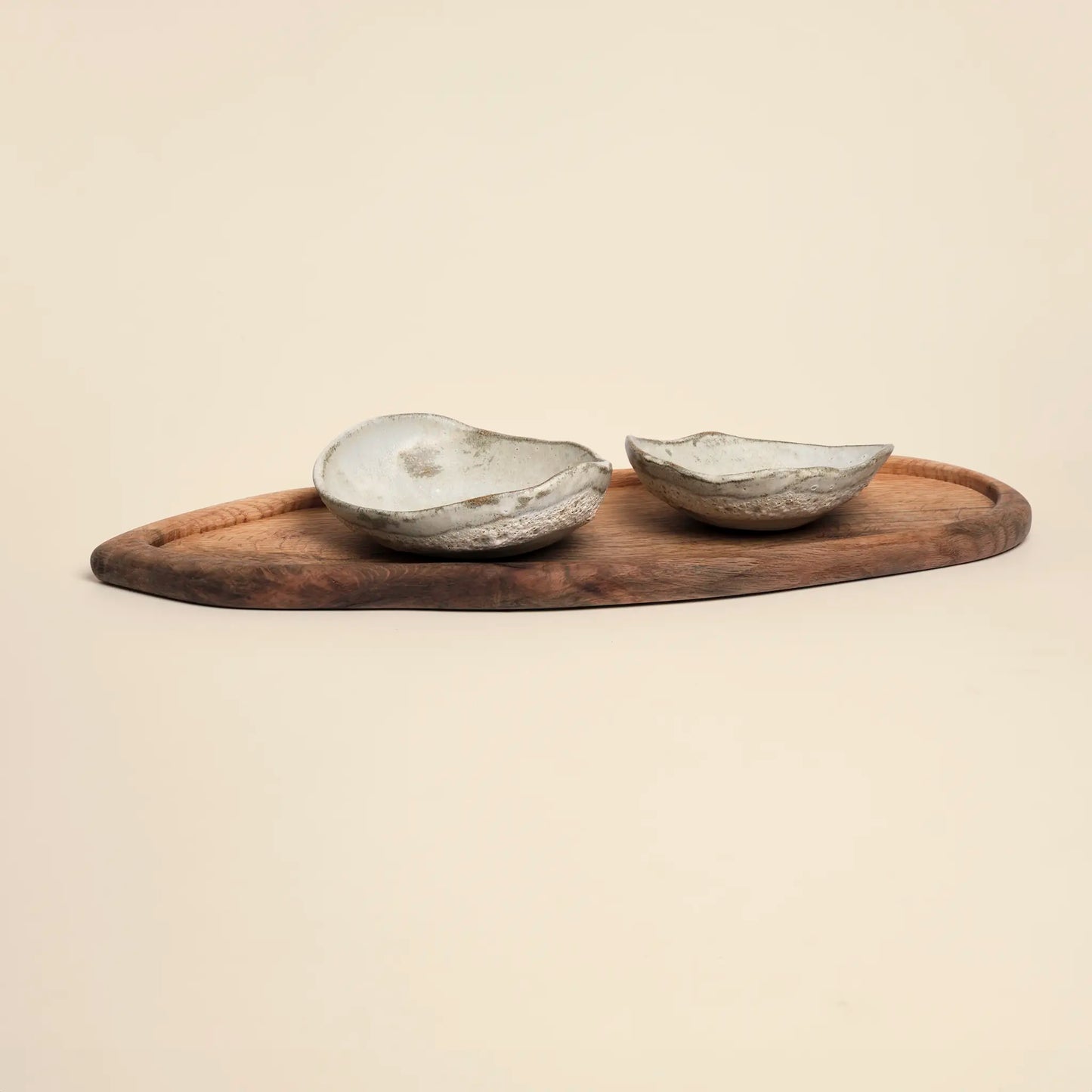 Lava Pulse Ceramics Set is a handmade set of two small ceramics bowls on a wooden board.