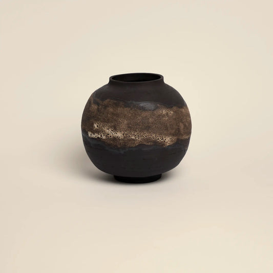 Ceramics vase with golden glaze and dark brown background