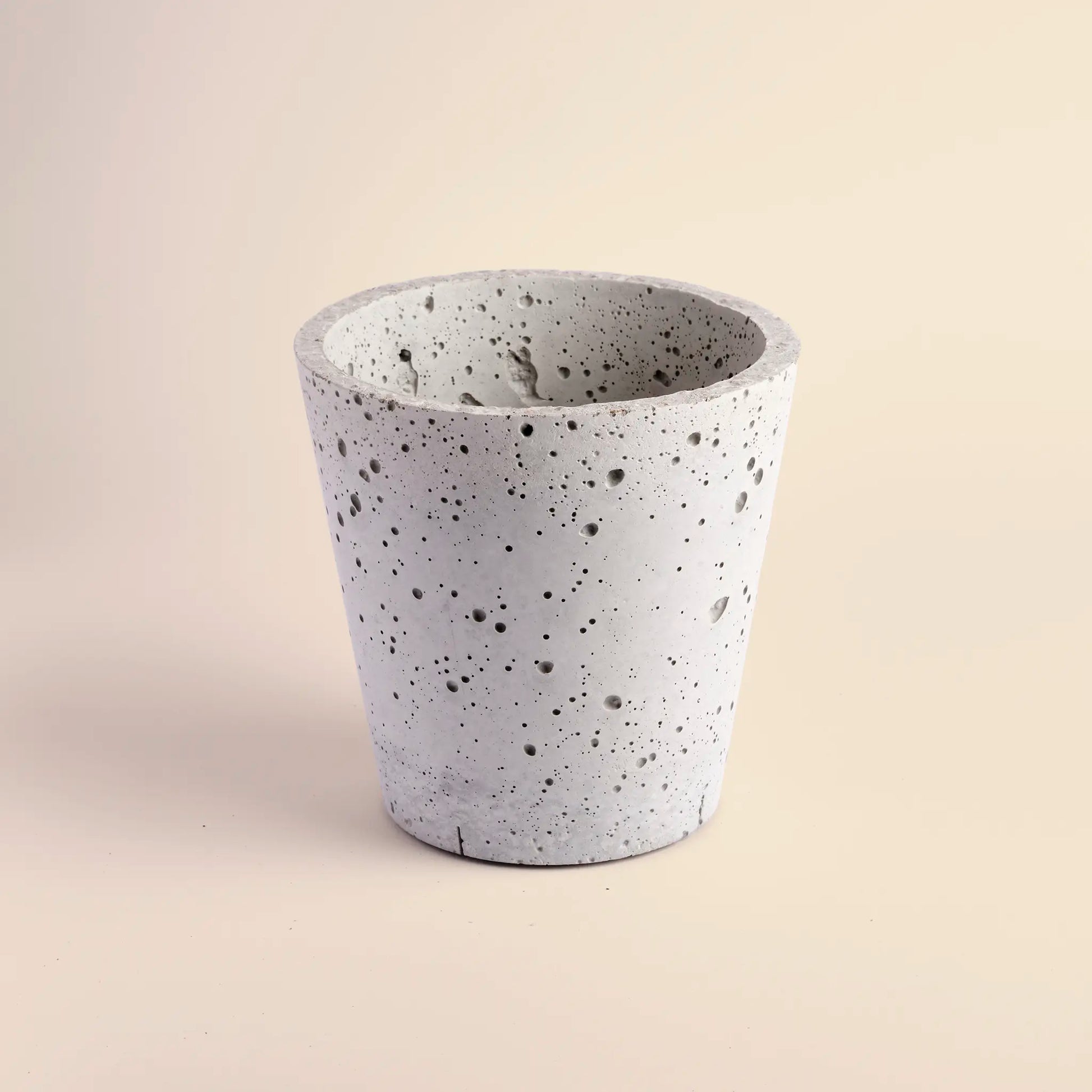 Medium plant pot handmade from concrete. It is  a cone shape with with decorative circular dents.