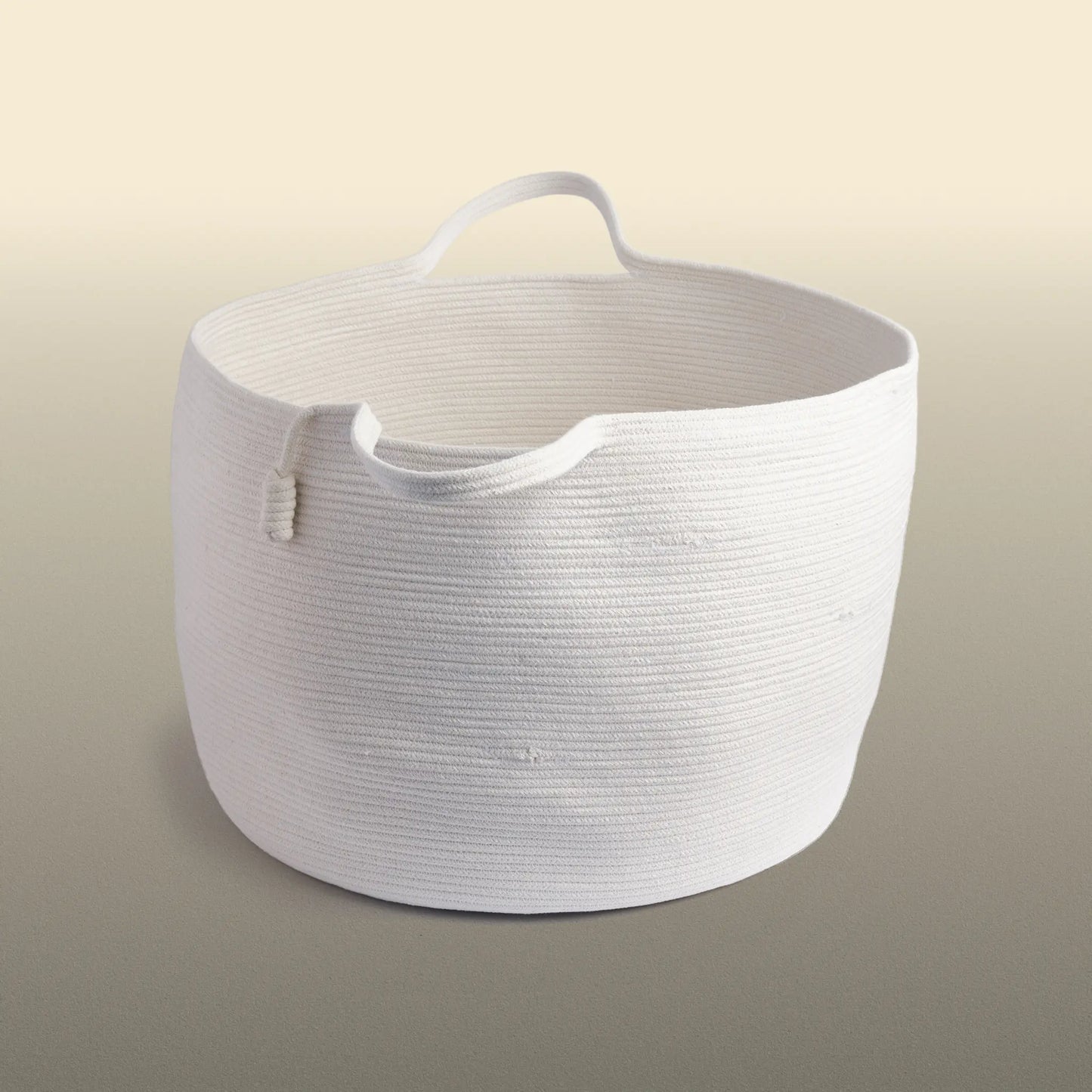 Homeware basket handmade from white cotton. The basket is round and has two handles. 