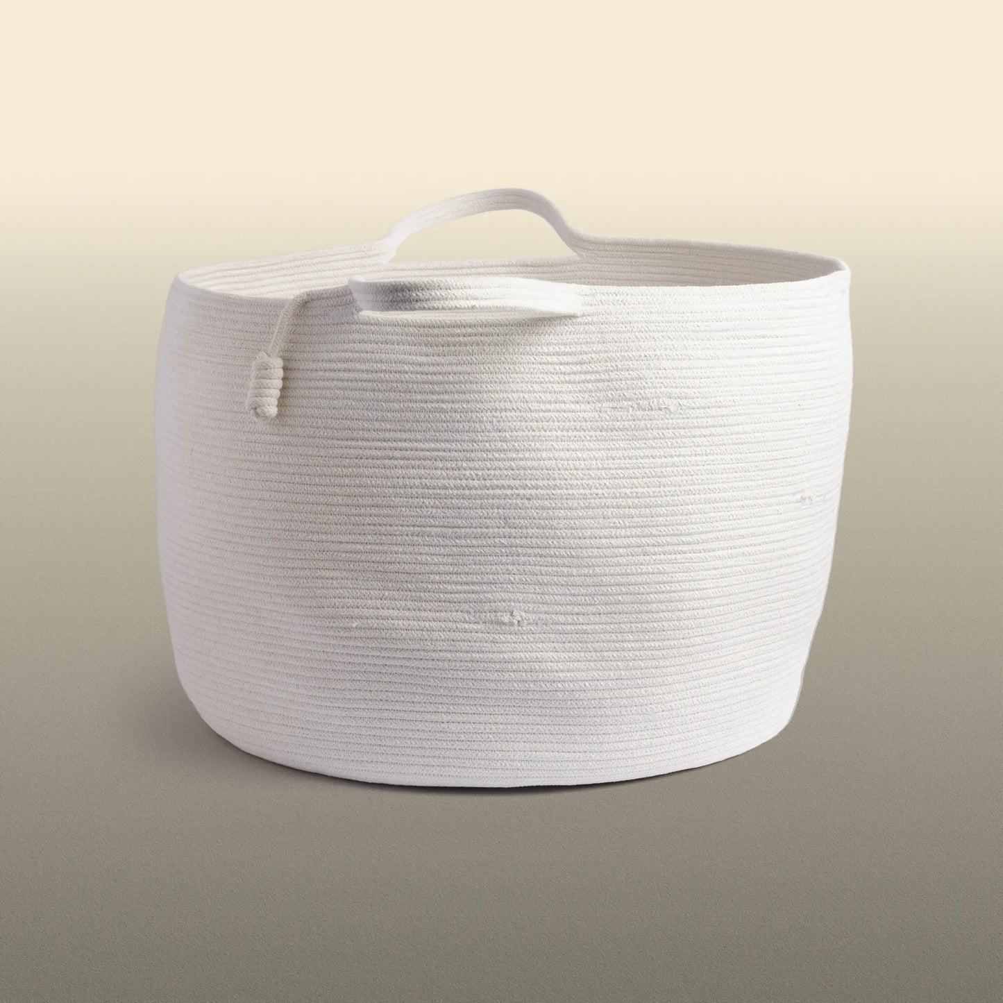 Homeware basket handmade from white cotton. The basket is round and has two handles. 